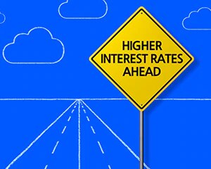 señal de carretera amarilla que dice “tasas de interés más altas a la vista”