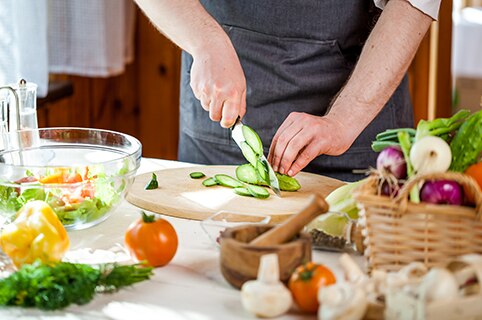 Person chopping vegetables in kitchen