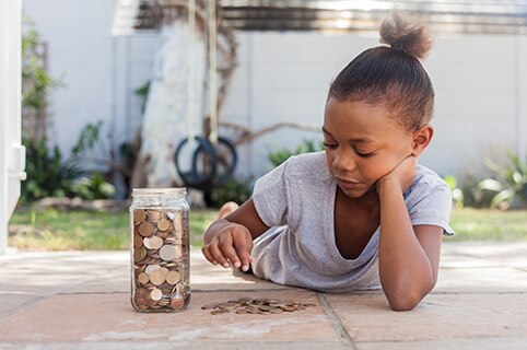 Little girl counting change from a jar