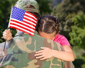 Chica abrazando un padre militar