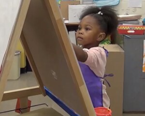 child painting on easel