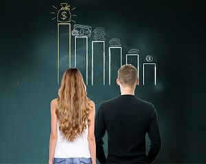 hombre y mujer jóvenes mirando un gráfico de crecimiento del dinero
