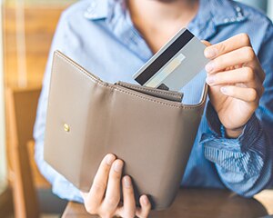 Mujer que coloca una tarjeta de crédito en la billetera