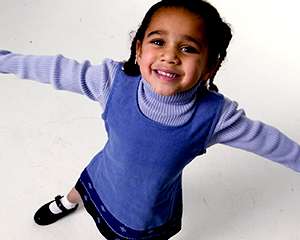 Foto elevada de una niña pequeña sonriendo y estirándose