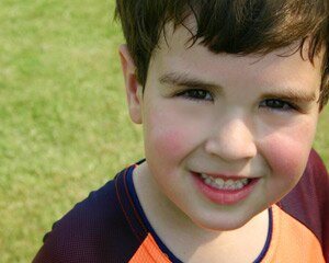 Un niño feliz con las mejillas rojas de jugar