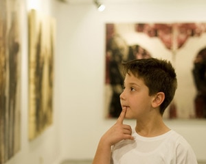 Niño joven viendo arte en una galería