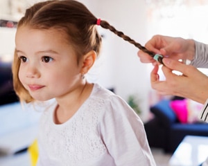 child getting hair braided