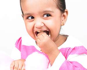  Photo of a small girl putting food in her mouth