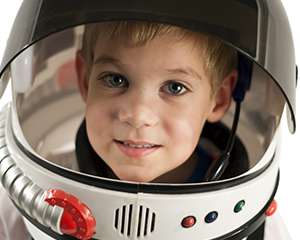 Photo of a young boy smiling in a space helmet