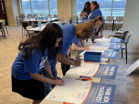 PNC employees of Grow Up Great in Kansas City, MO sign posters as appreciation to pre-K teachers