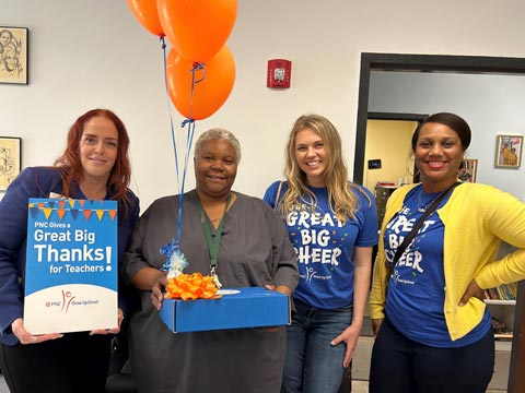In St. Louis, MO PNC employees Amber Briggs, Alisha Abbott and Billie Goode present Uni Pres KinderCottage early childhood educator Ms. Catrice with gifts from PNC