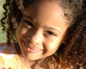 Niña joven con el sol brillando en su rostro