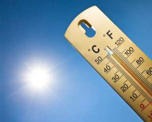 Thermometer outside with sun in the background