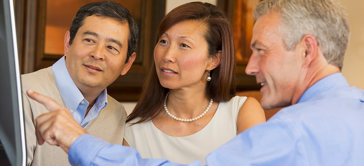 Couple looking at computer with their financial advisor