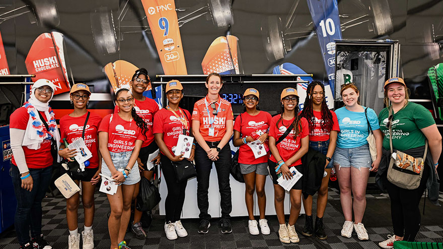 Angela Ashmore, Assistant Race Engineer, posing with a group of women for Girls at the Track Day