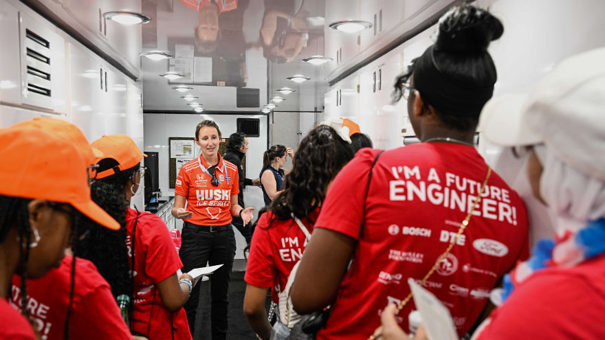 Angela Ashmore, Assistant Race Engineer, speaking with a group of women at Girls at the Track Day