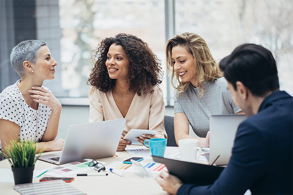 four people sitting around and office table having a conversation
