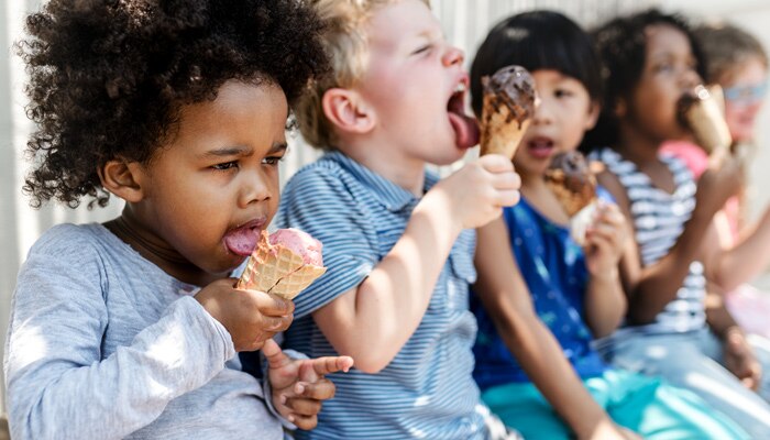 Group of toddlers sitting eating ice cream cones