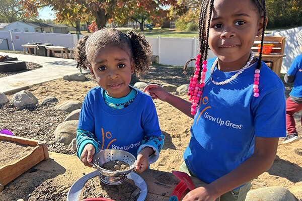 Nature based play and learning space in Northern Indiana with children playing with sand.