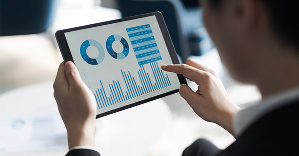someone reviewing charts and graphs on a tablet
