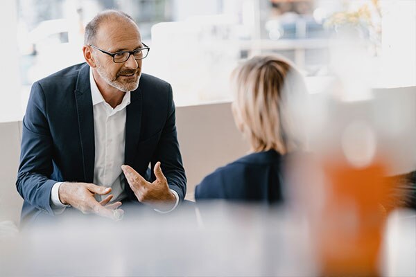 A man sitting in a chair having a discussion with a female