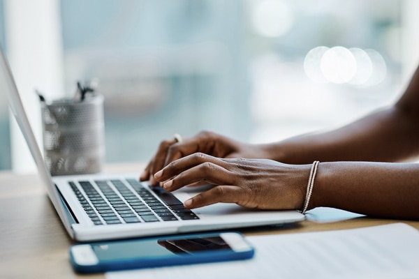 closeup of a woman's hands typing on a computer